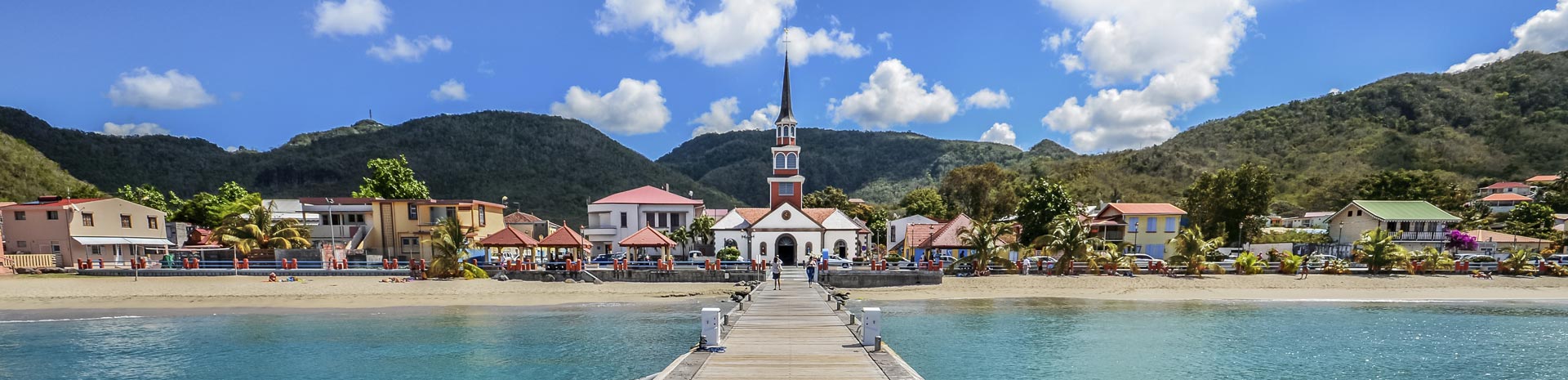 A picturesque coastal village with colorful houses and a church, viewed from a pier | MSC Cruises A picturesque coastal village with colorful houses and a church, viewed from a pier | MSC Cruises