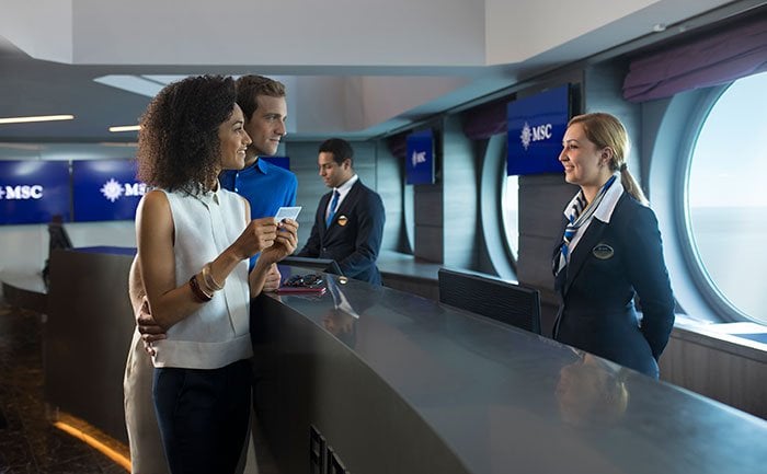 Guests checking in at the reception desk onboard an MSC cruise ship | MSC Cruises Guests checking in at the reception desk onboard an MSC cruise ship | MSC Cruises