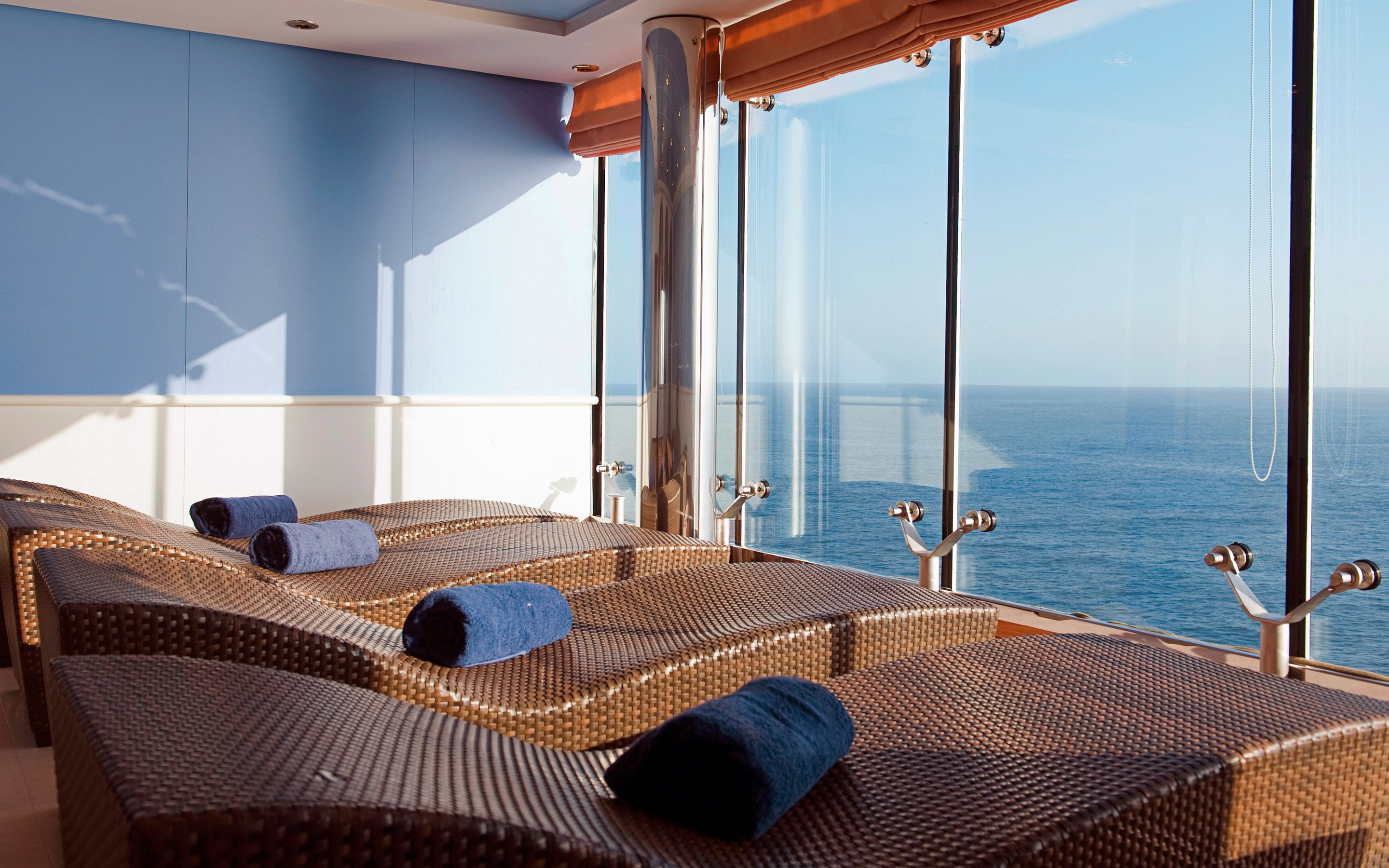 Relaxation area with wicker loungers and ocean views through large windows | MSC Cruises Relaxation area with wicker loungers and ocean views through large windows | MSC Cruises