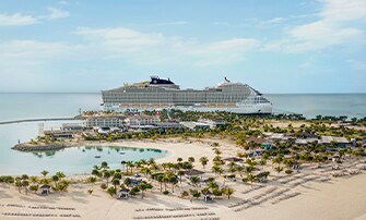 A luxury MSC cruise ship docked near a private island with palm trees and clear waters | MSC Cruises